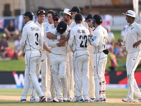 New Zealand team celebrating after taking a wicket.